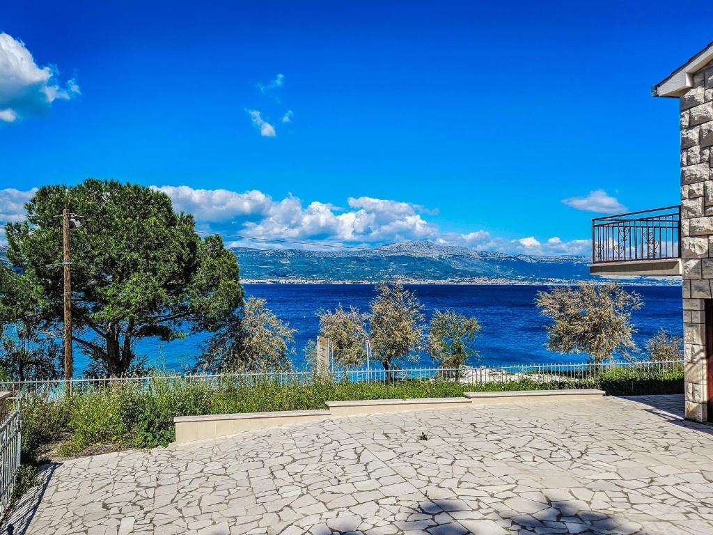 a stone patio with a view of the water at Holiday Home Robert by Interhome in Trogir