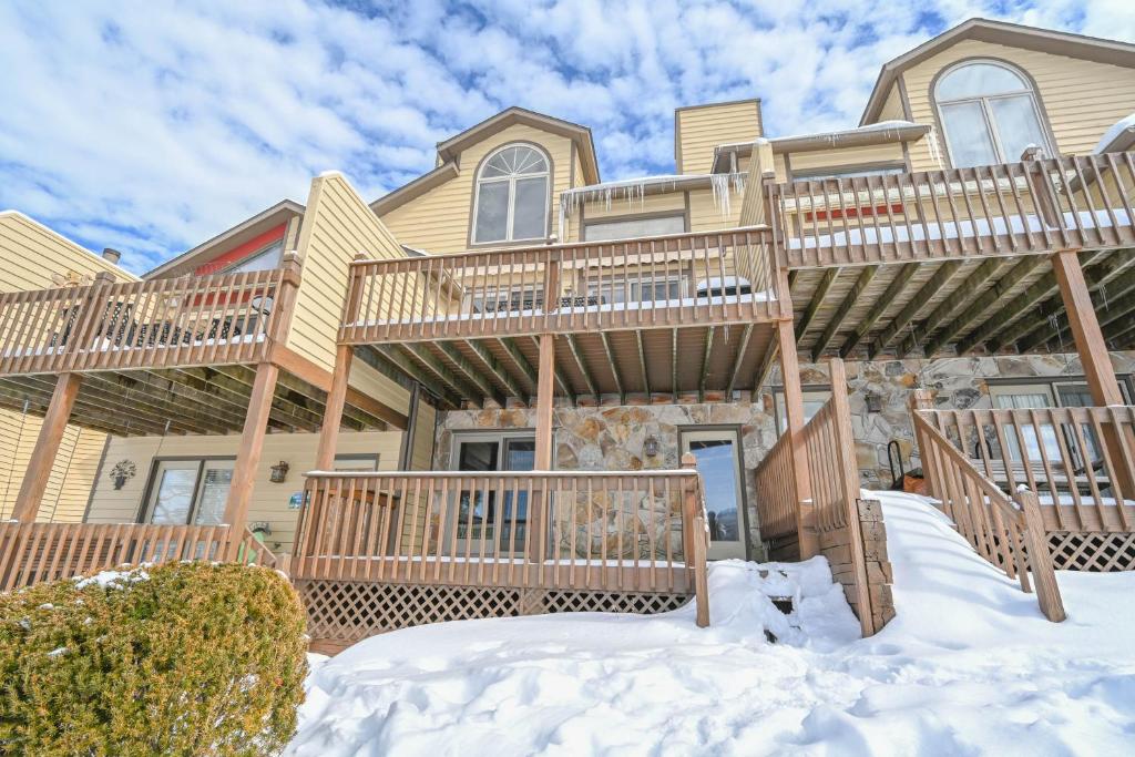 a house with a deck in the snow at DC Love Shack by Railey Vacations in McHenry