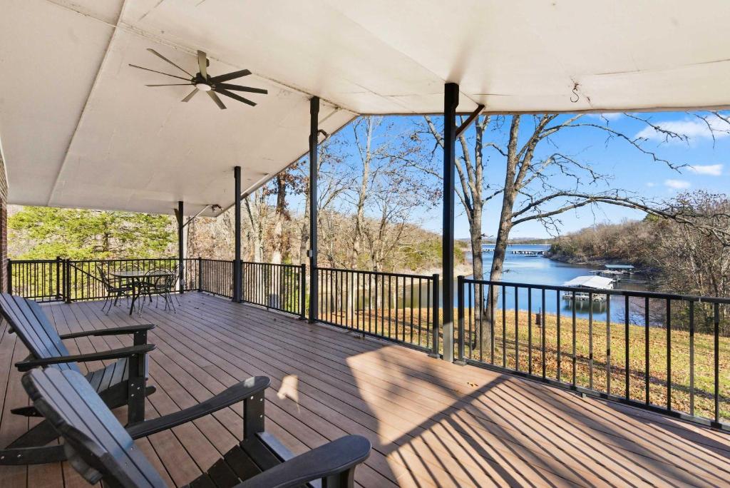 a deck with chairs and a view of the water at Lakeside Brick Retreat For 8 in Branson West