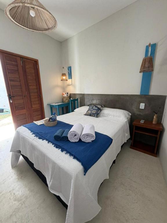 a bedroom with a large bed with two hats on it at Pousada Villa Santorini Preá in Cruz