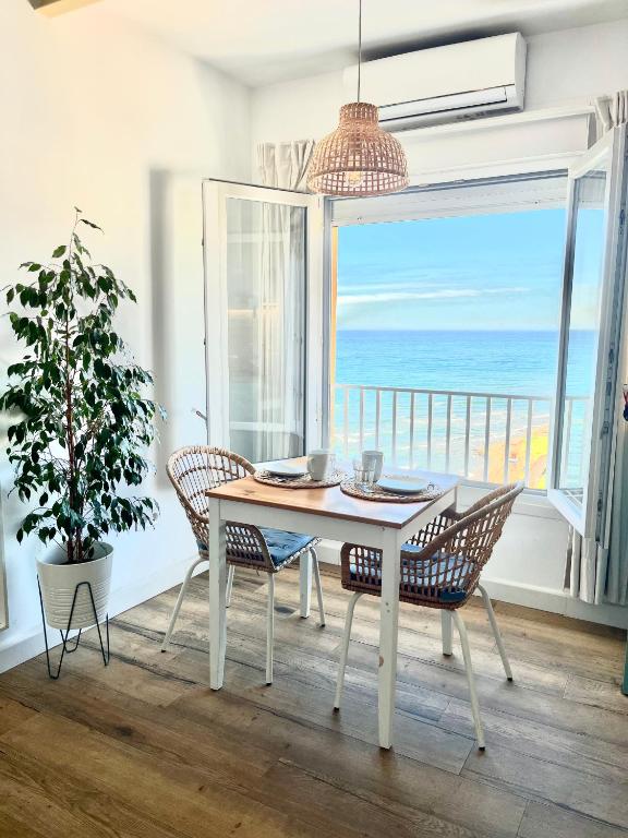 a dining room with a table and a view of the ocean at Studio on the Beach Front in Sitio de Calahonda