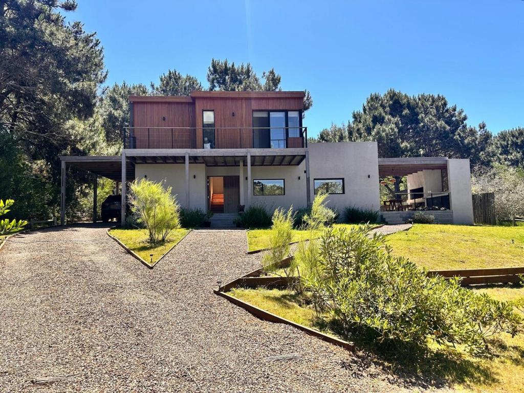 a modern house with a large yard with a driveway at Casa Amapola in José Ignacio