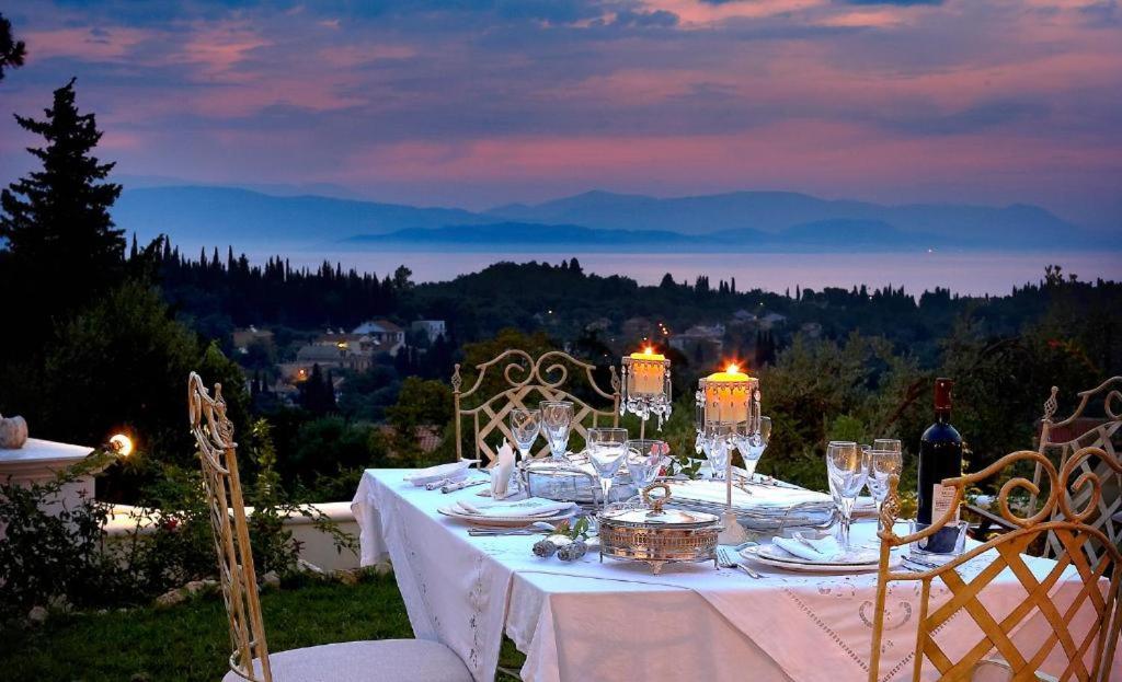 a dinner table with a white table cloth and chairs at Corfu Olive Village with Swimming Pool Castello Di Vista in Análipsis