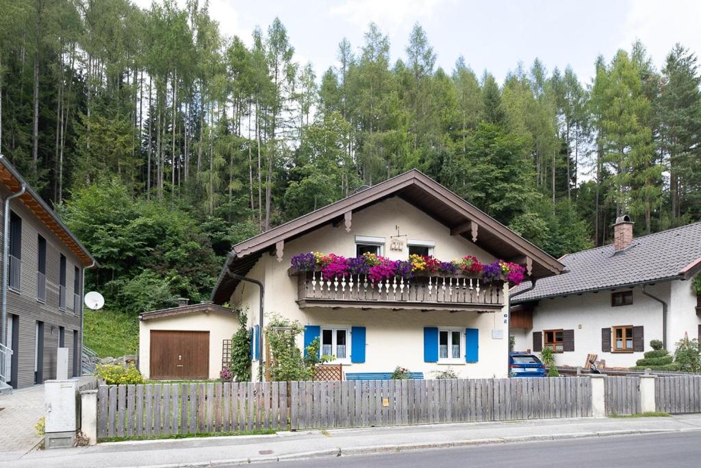a house with a balcony with flowers on it at Alpenwohnung "Zum Schorschi" mit Bergblick I voll ausgestattet I ruhige Lage in Oberammergau