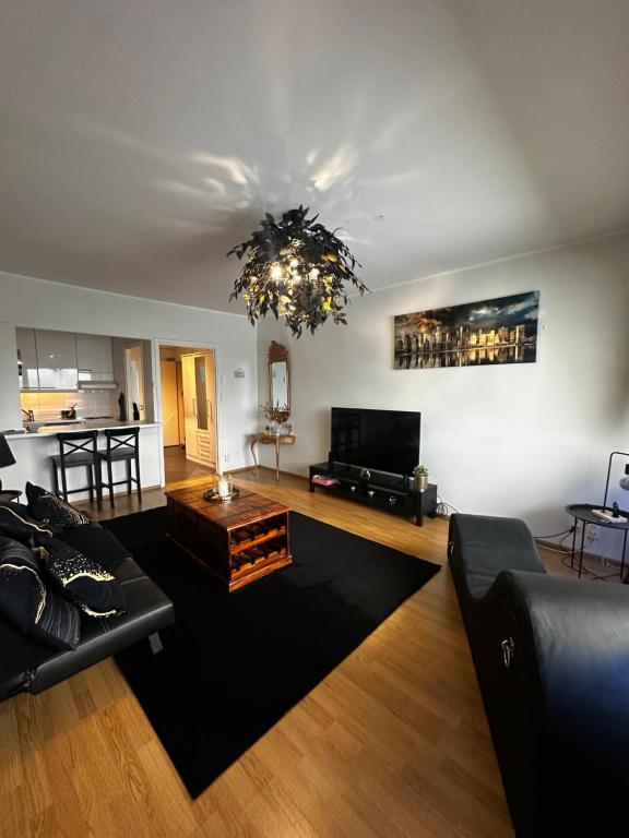 a living room with a couch and a chandelier at Lemmenpesä Ytimessä in Oulu