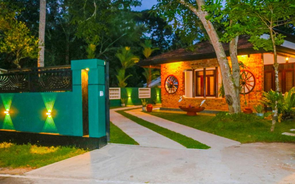 a house with a green box in front of it at Nature Forest Villa in Hikkaduwa