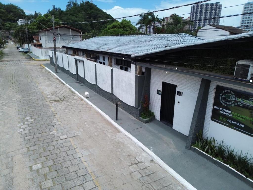 an empty street next to a white building at Praia dos Sonhos - Suítes in Itanhaém