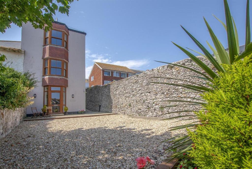 a house with a stone wall next to a building at 1 Bed in Seaton oc-mbsov in Seaton