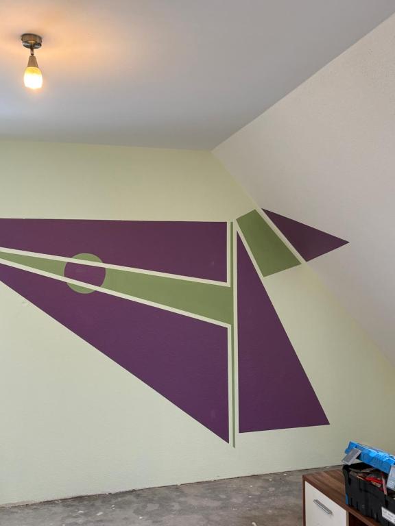 a wall with a painting of a scissors at Red Dot Apartment Lucky in Kamen