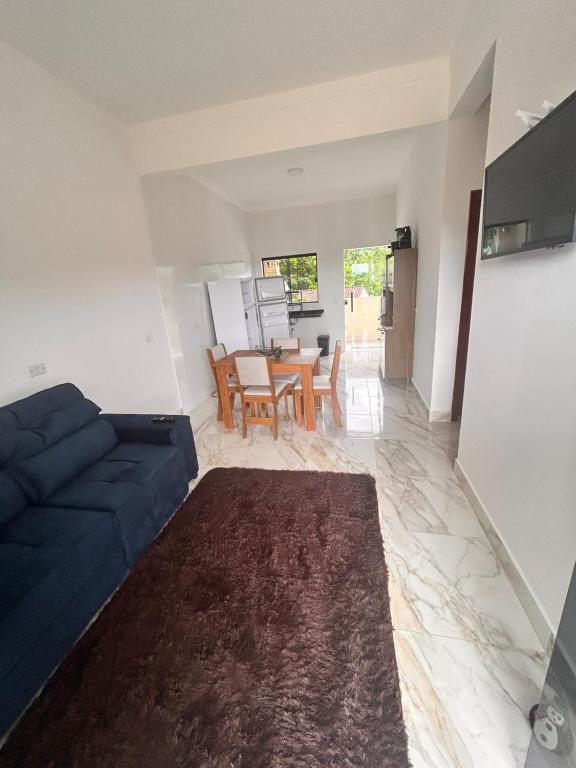 a living room with a blue couch and a table at CONDOMINIO JT ll in Ubatuba