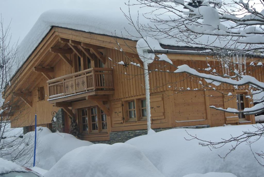 domek z bali na śniegu z balkonem w obiekcie Chalet Mine de rien w mieście Megève