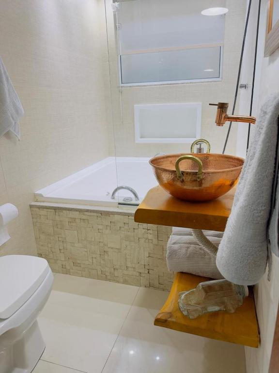 a bathroom with a bowl sink and a bath tub at Deruci Chale in Nova Friburgo