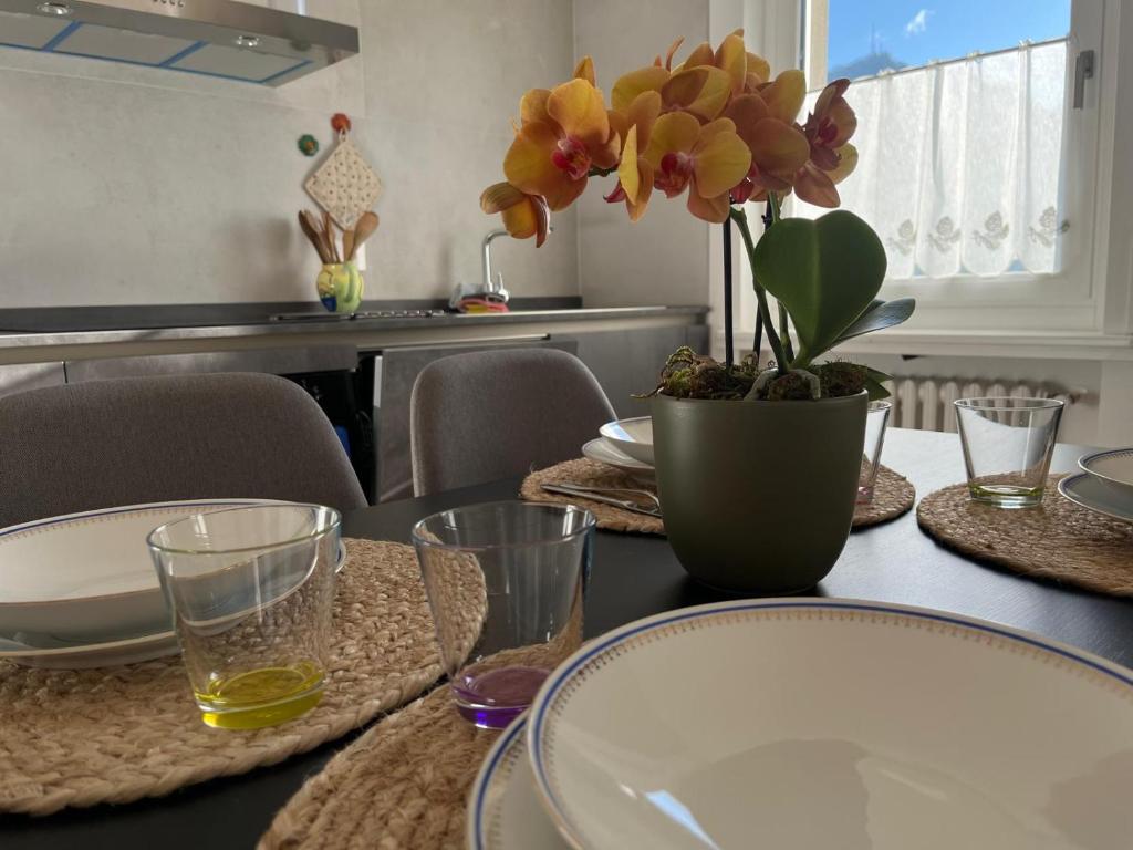 a dining room table with a vase of flowers on it at Tra prati e monti - Dolomiti Bellunesi in Valle di Cadore