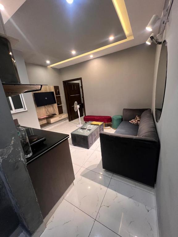 a living room with a couch and a tv at HNC Arcade in Dargai