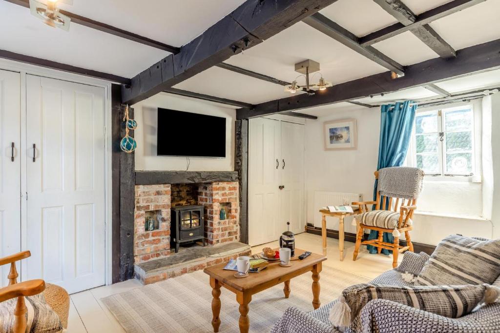 a living room with a fireplace and a tv at 1 Bed in Looe oc-l30002 in Looe