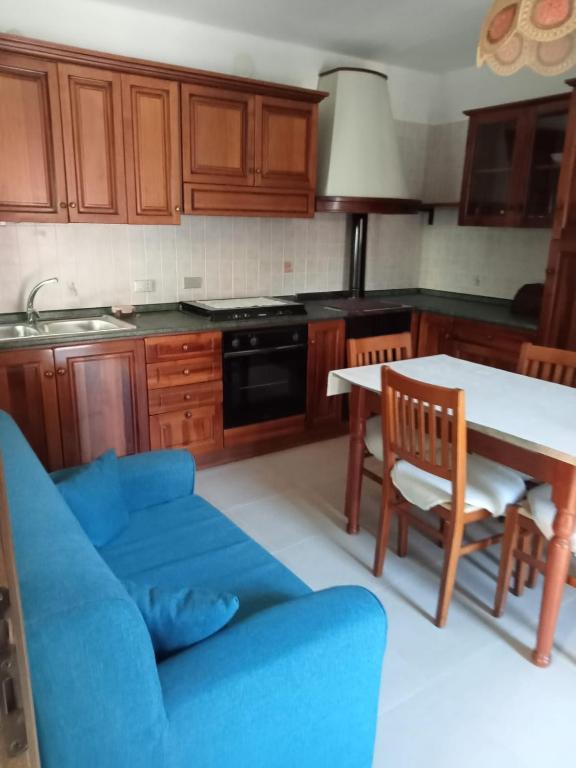 eine Küche mit einem blauen Sofa und einem Tisch in der Unterkunft Seconda Casa in Boves