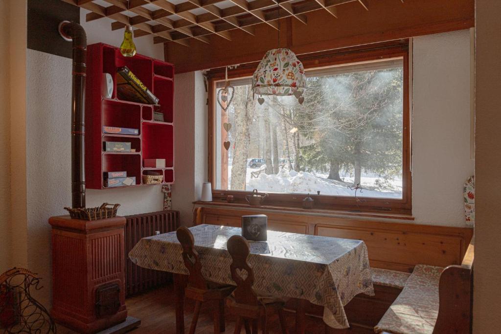 a dining room with a table and a window at Prali Ski House - 4beds - Parking - Garden in Prali