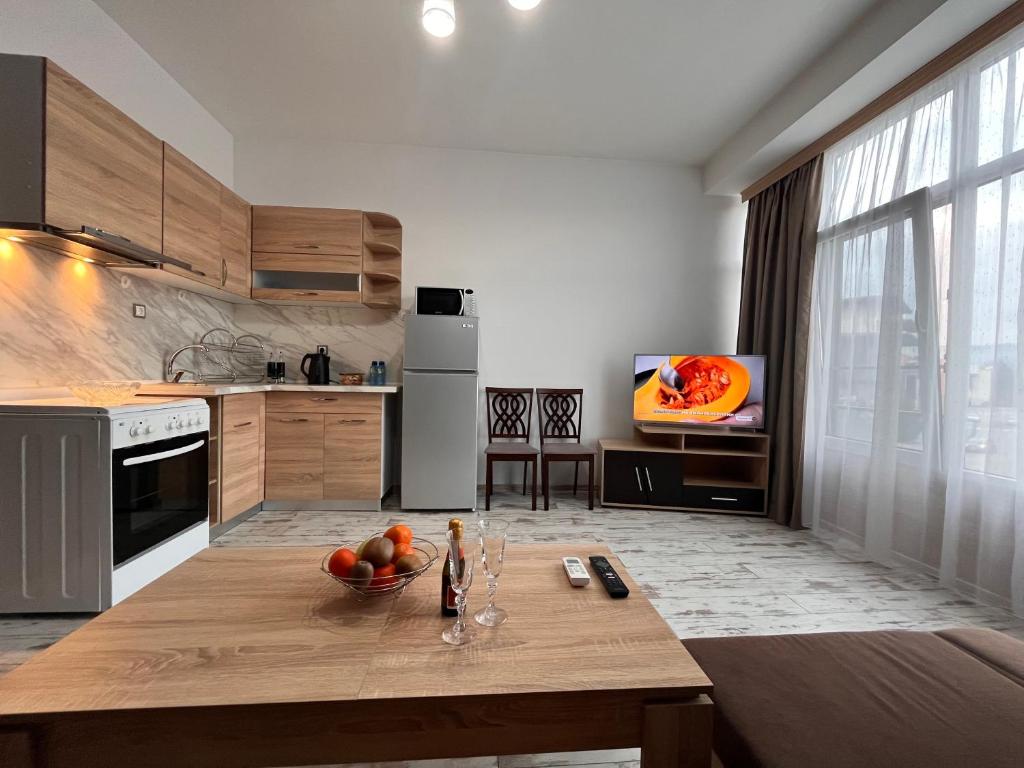 a kitchen with a table with a bowl of fruit on it at Апартамент Аксел in Panagyurishte