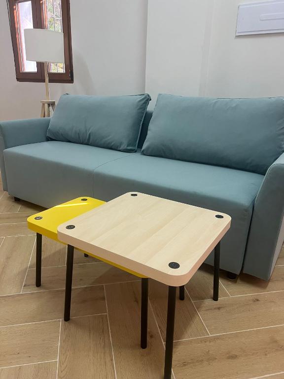 a blue couch with a wooden coffee table in front of it at Apartamento Villuercas in Cañamero