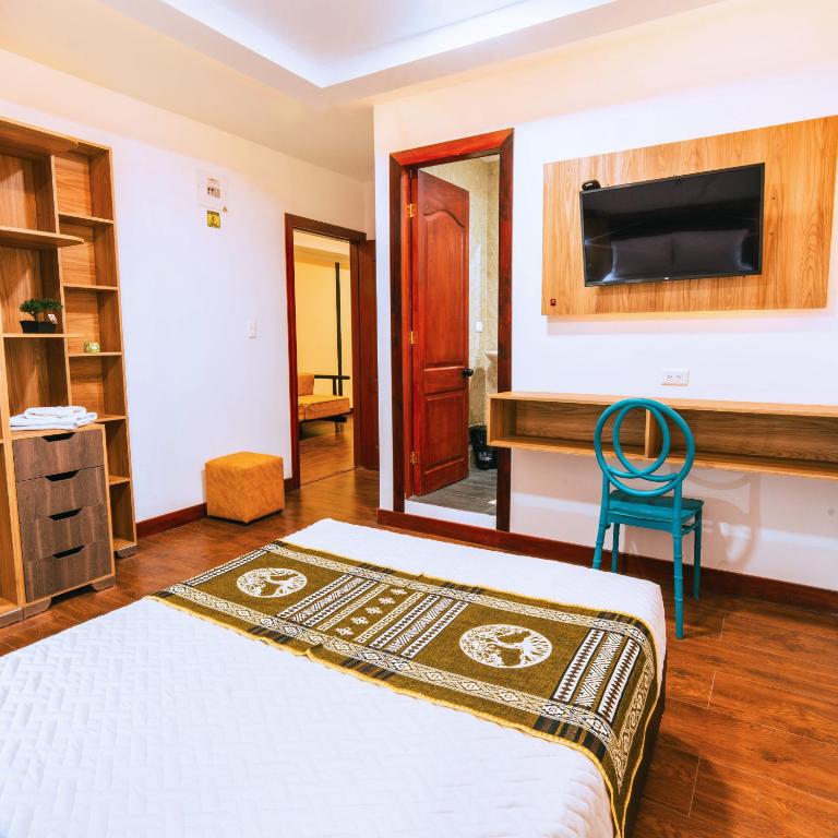 a bedroom with a bed and a tv on a wall at Hotel Casa Santiago in Pasto