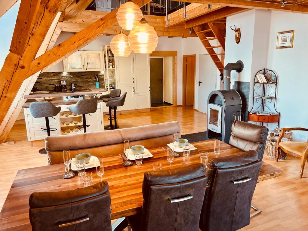 a dining room with a wooden table with leather chairs at Badischhaus am Waldrand & Weitblick in Herrischried