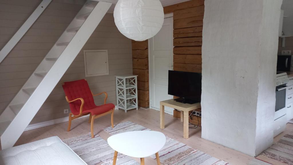 a living room with a red chair and a tv at Lohusalu Apartment in Lohusalu