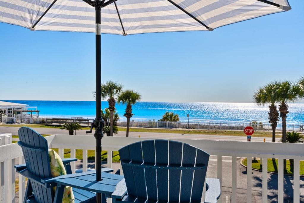 a table with chairs and an umbrella on the beach at Beach Escape, King Suite, Ocean Views, Pet Friendly in Destin