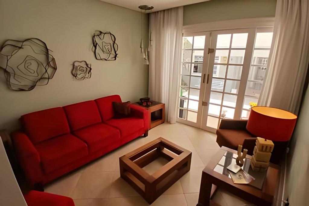 a living room with a red couch and a table at SHB - Beach House with Air Conditioning in Santos