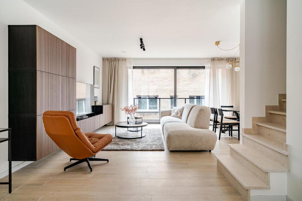 a living room with a couch and a chair at Casa Blanc - Coastal Triplex in Blankenberge