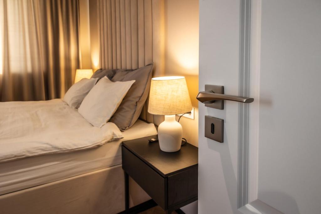 a bedroom with a bed and a table with a lamp at Smarald Apartment in Satu Mare