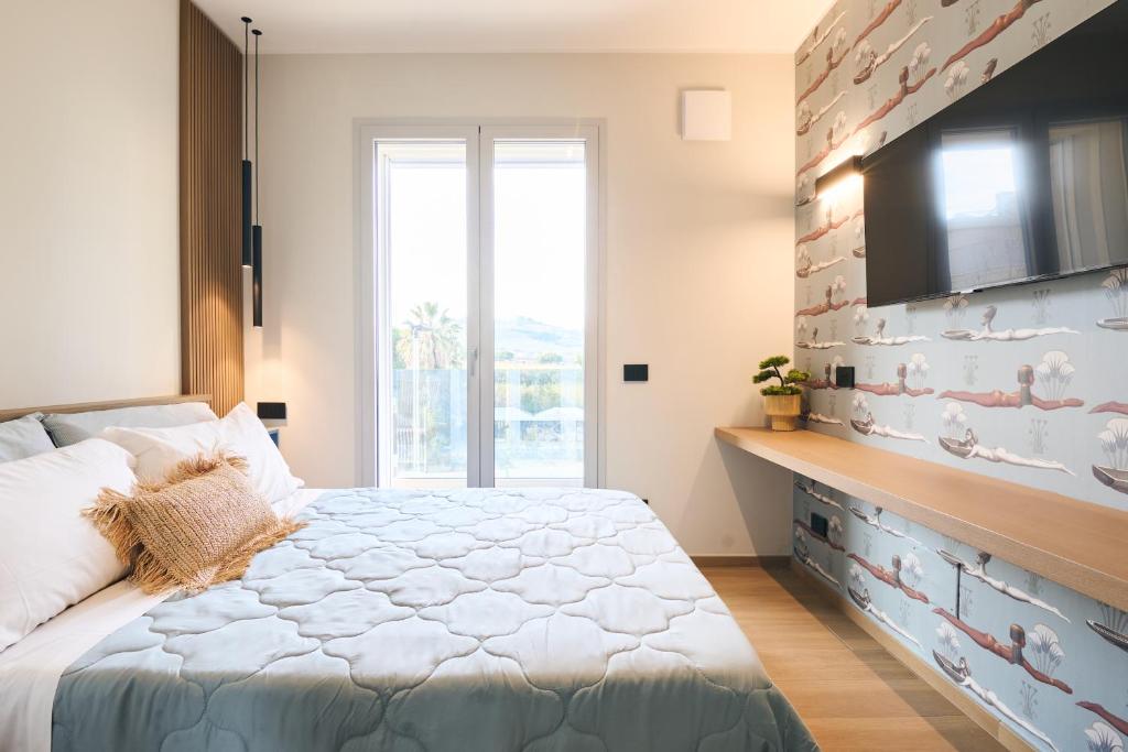 a bedroom with a bed and a flat screen tv at À la plage B in San Benedetto del Tronto