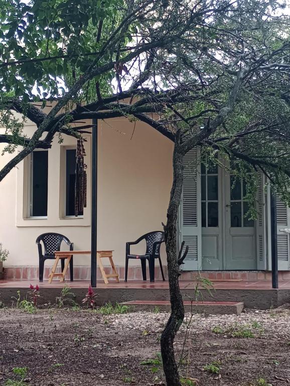 two chairs and a table in front of a house at Tacuarita in Los Hornillos
