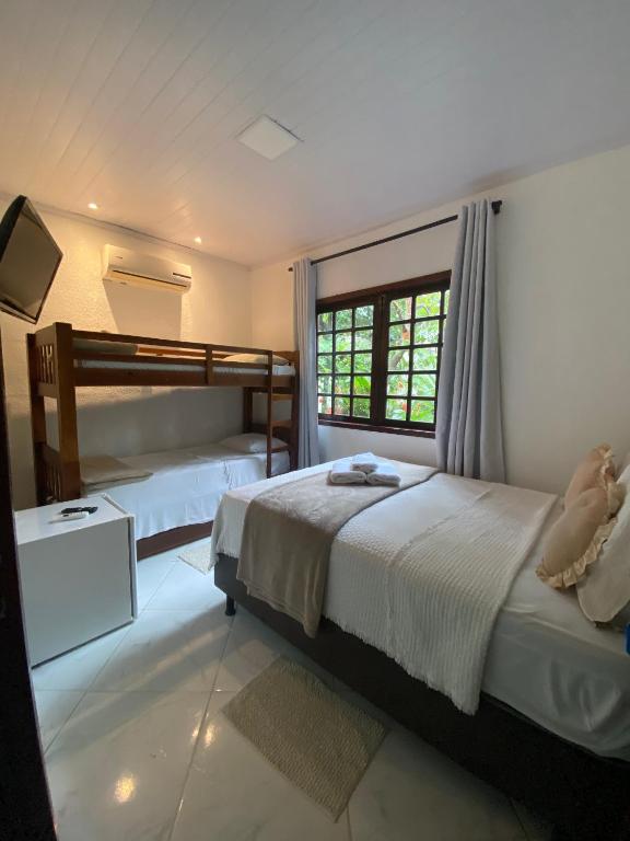 a bedroom with two bunk beds and a window at LEGATUM POUSADA - Próx a BR 101 e Partage Shopping in Campos dos Goytacazes