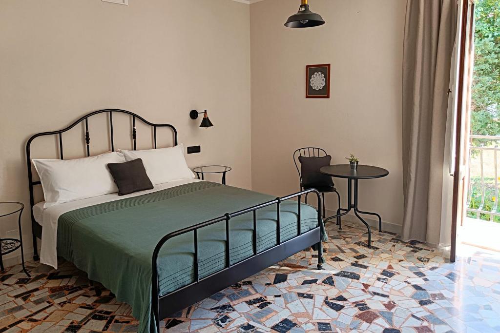 a bedroom with a bed and a table at SUVAJ Rooms in Galatro