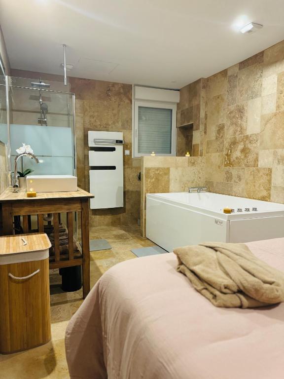 a bathroom with a bed and a bath tub at Gîte le Nid Dhugava in Hem-Hardinval