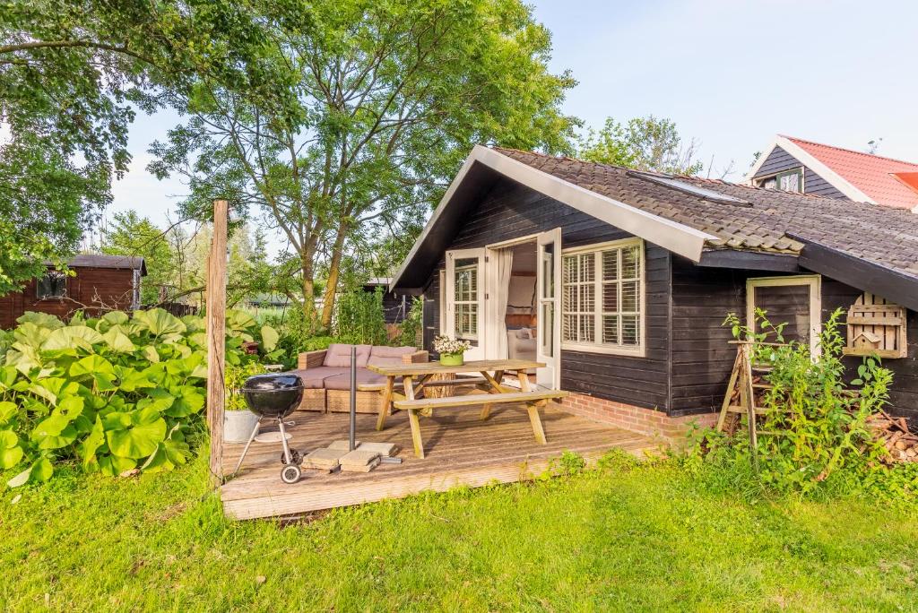 a small house with a wooden deck in the yard at farmhouse in Wijdewormer