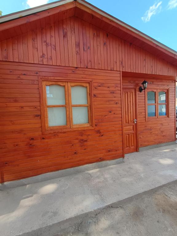 a large wooden building with two windows at Cabaña Mailin in Uspallata