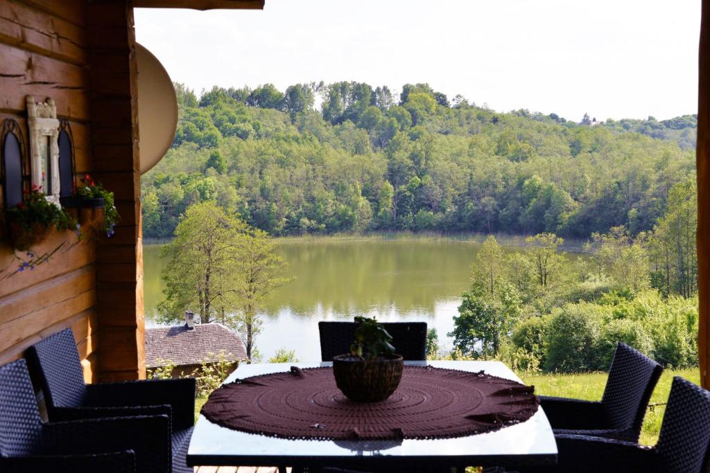 a table with a view of a lake from a house at Prie Melnyčios in Dubingiai