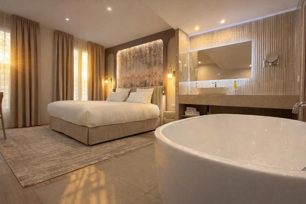 a bathroom with a tub and a bed and a sink at Bobo's hotel in Paris