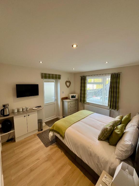 a bedroom with a large bed and a television at Acorns in Hordle