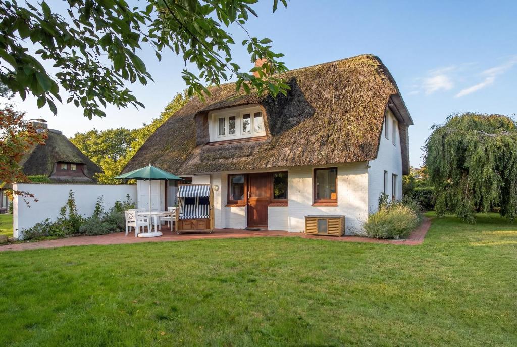 a cottage with a thatched roof and a yard at Dat Reethuus in Böhl