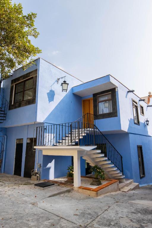 a blue house with a staircase in front of it at Pasaje Las Rosas in Cuernavaca