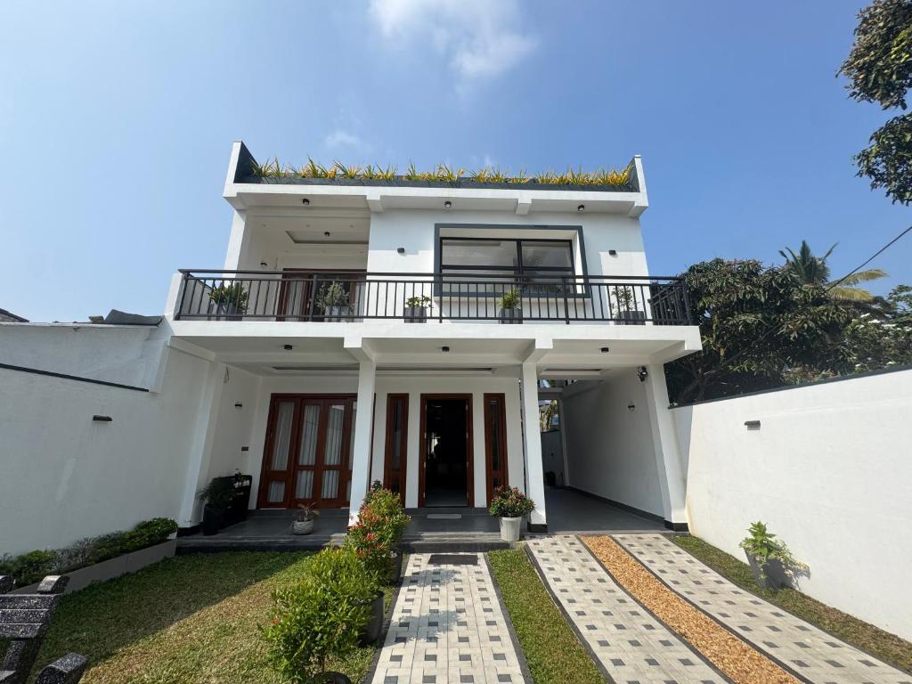 a white house with a balcony on top of it at Ferien Villa in Kalutara