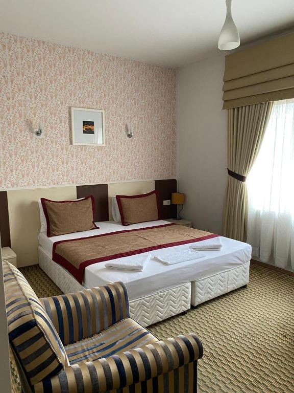 a hotel room with two beds and a chair at Legend Tem Hotel in Silivri