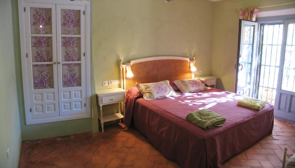 エル・カスティージョ・デ・ラス・グアルダスにあるCasa rural Las Tejonerasのベッドルーム1室(赤いベッドカバー付)