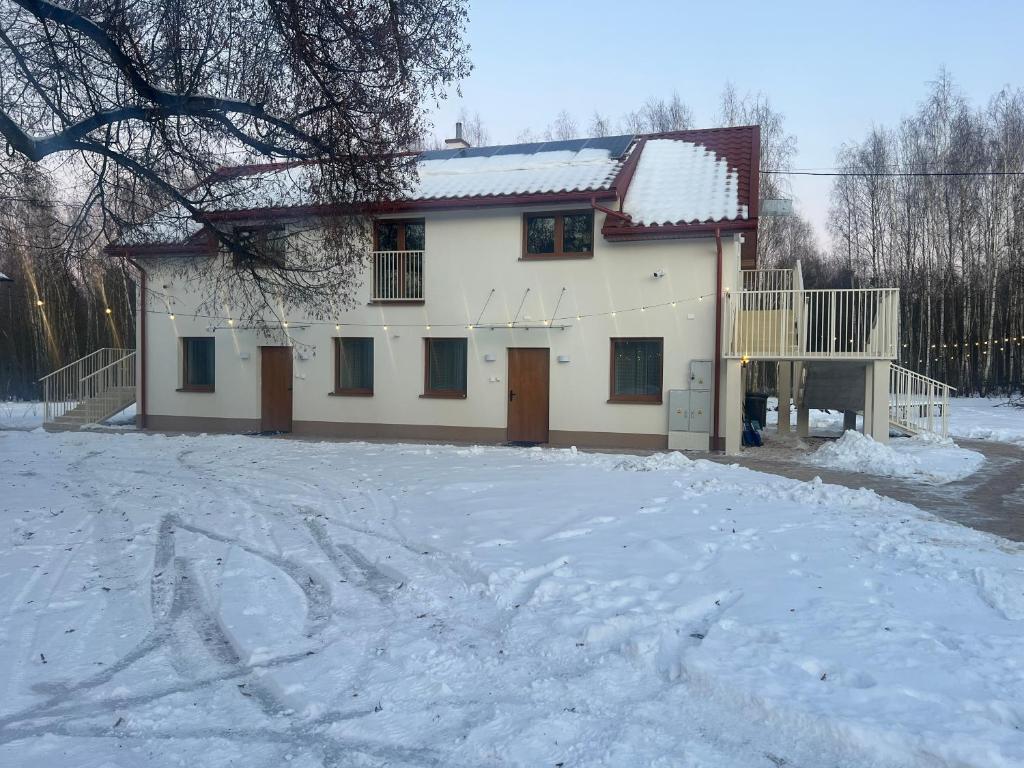 a white house in the snow with a yard at Apartamenty obok Suntago Park of Poland parking gratis in Wręcza
