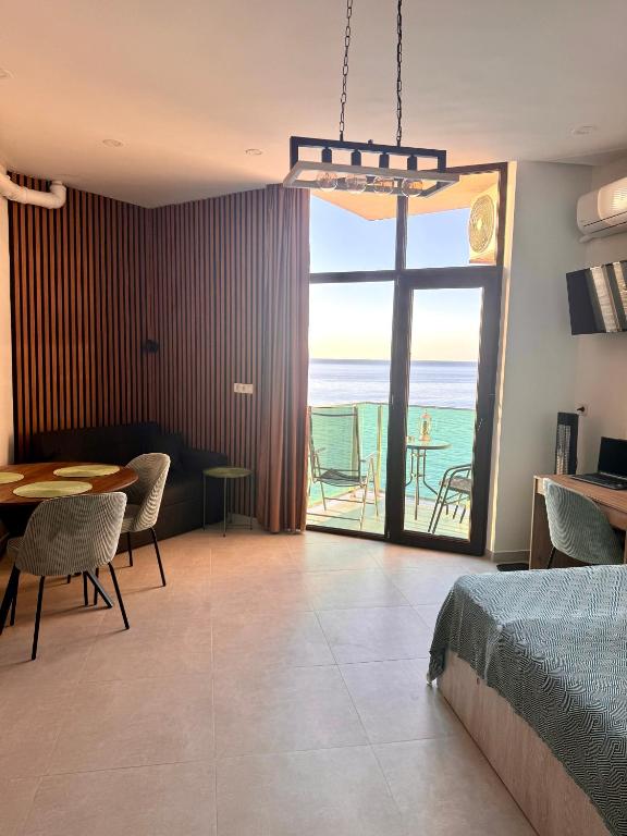 a bedroom with a bed and a table with a view of the ocean at Seafront Gonio Studio in Gonio