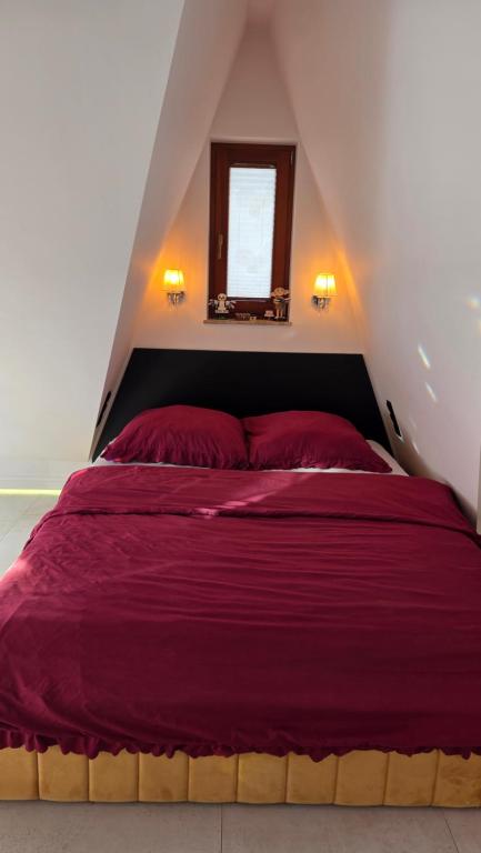 a bedroom with a large red bed with a window at Urocze Gniazdko pod Tatrami in Ratułów