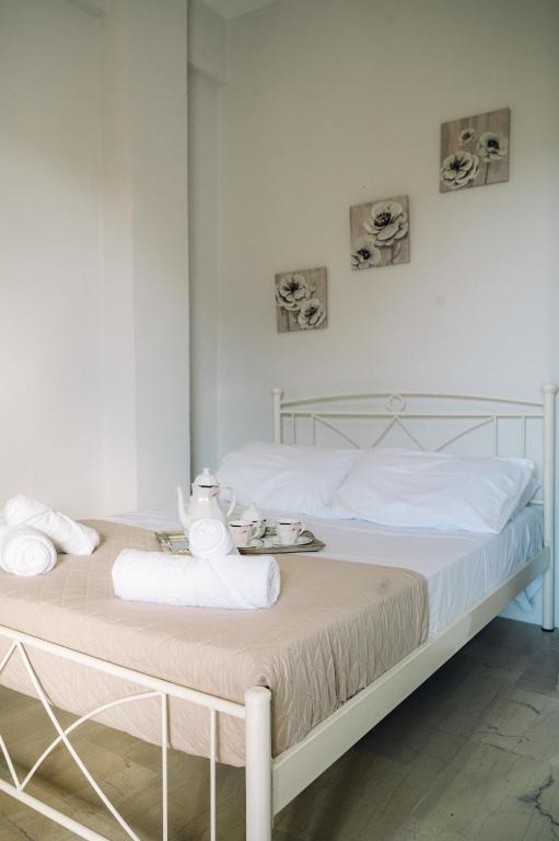 a white bedroom with a bed with towels on it at Γκαρσονιέρα δίπλα στη θάλασσα. in Kómi