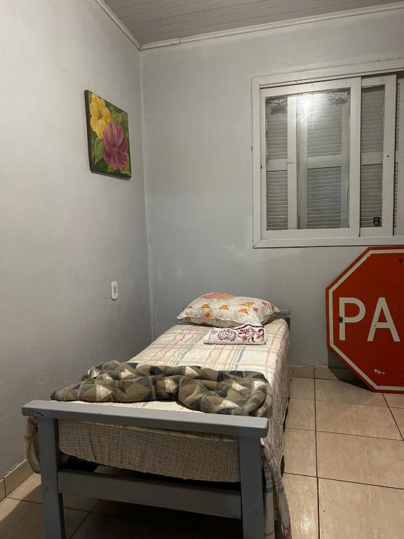 a small bed in a room with a window at Pousada da Drika in São Gabriel
